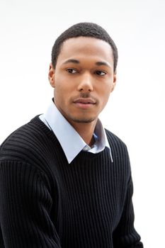 Handsome African American male in blue shirt and black sweater, isolated