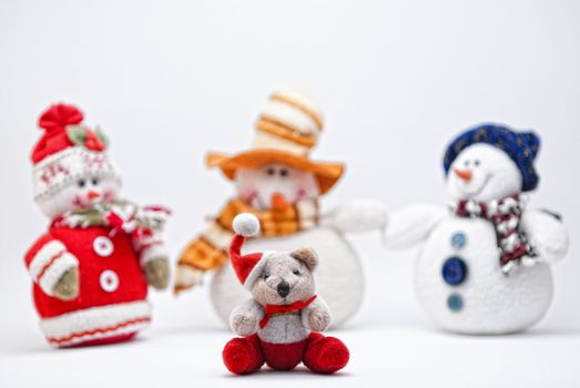 Christmas Teddy (Selective Focus) and three Snowmen on a white background.