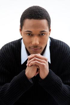 Handsome African American male in blue shirt and black sweater, isolated