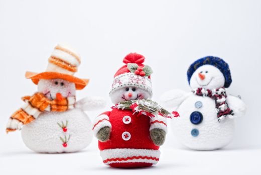 Three Snowmen (selective focus) on a white background.