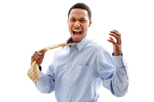 Angry screaming African American business man in blue shirt pulling yellow tie, isolated