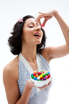 Happy beautiful candy girl with eyes closed about to eat a bubblegum candy, isolated