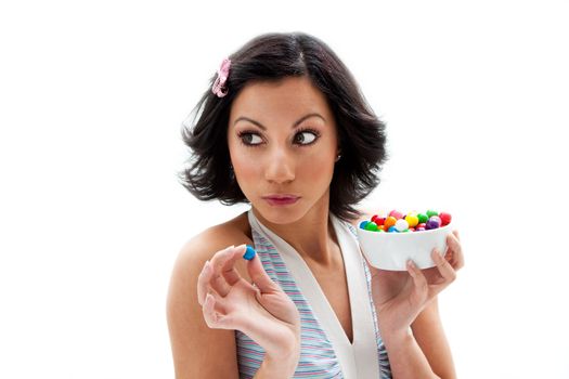 Happy beautiful candy girl looking to the side about to eat a bubblegum candy, isolated