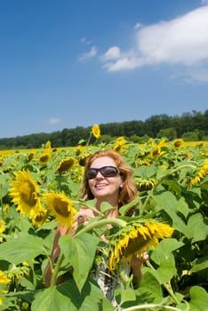 The beautiful woman in the field of sunflowers