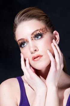 Tilted face of a beautiful dirty-blond girl with leopard print eyeshadow, isolated