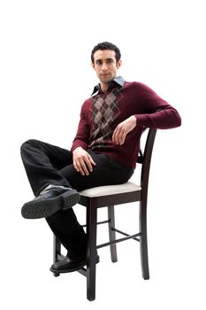 Handsome guy wearing business casual clothes sitting on a high chair with legs crossed and arm resting, isolated