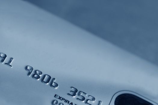 A close-up of a credit card, cast in blue.