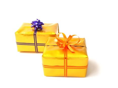 resent boxes in gold wrap and colorful belts with bows on white background