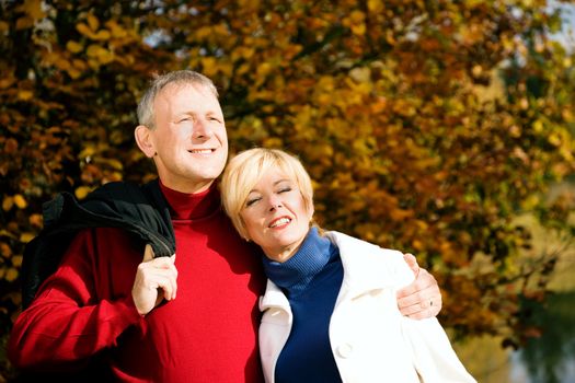 Mature couple deeply in love having a walk holding each other tight