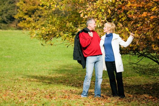 Mature couple deeply in love having a walk holding each other tight
