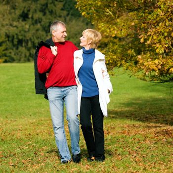 Mature couple deeply in love having a walk holding each other tight