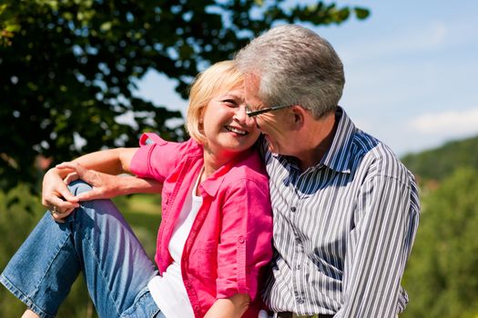 Visibly happy mature or senior couple outdoors arm in arm deeply in love