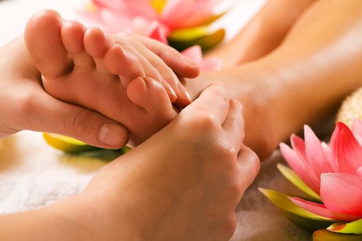 Woman enjoying a feet massage in a spa setting (close up on feet)