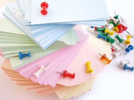 colorful sheets and push pins on white background