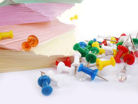 colorful sheets and push pins on white background