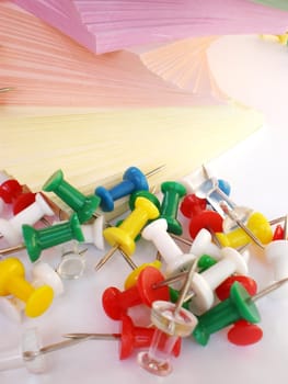 colorful sheets and push pins on white background