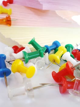 colorful sheets and push pins on white background