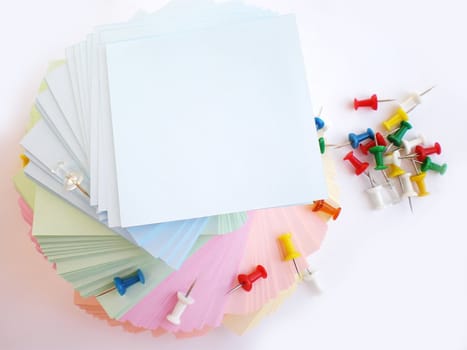 colorful sheets and push pins on white background