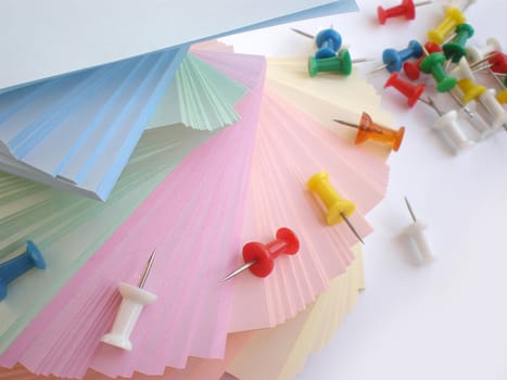 colorful sheets and push pins on white background