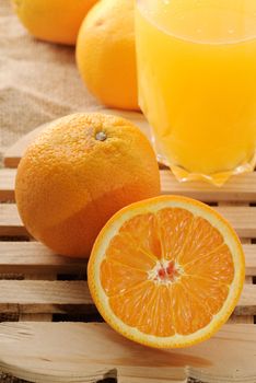 Fresh orange juice, closeup image with groups of fruit on desk.
