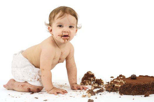 An adorable one year old girl enjoying her first birthday cake.