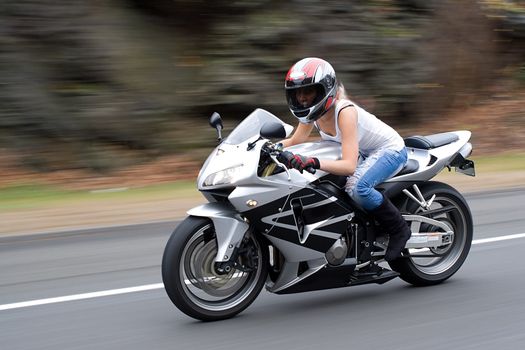 Abstract blur of a pretty girl driving a motorcycle at highway speeds.