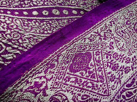 A closeup of a purple and grey tradiational indian fabric, known as the sari/saree