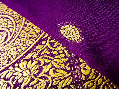 A closeup of a yellow and grey traditional indian fabric, known as the sari/saree