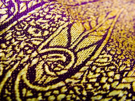 A closeup of a leaf design on a indian fabric, know as a a saree/sari