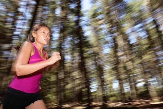 Running, Female runner running fast at great speed in forest. Mot�on blurred image of beautiful Asian / Caucasian woman athlete sprinting outdoors in tank top.