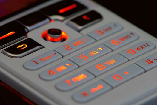 Close up shot of mobile keypad with light under dark