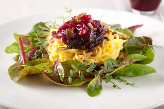 Delicious pasta dish with blood sausage and small mushrooms