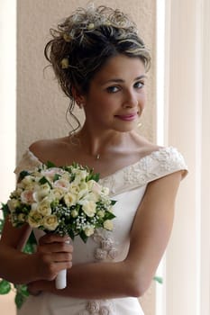 Smiling bride holding bouquet of flowers.
