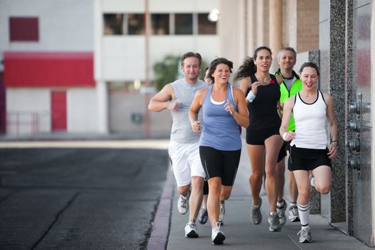 Men and women running for exercise downtown