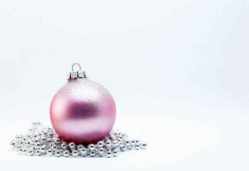 Pink Christmas Bauble with silver beads on a white background.