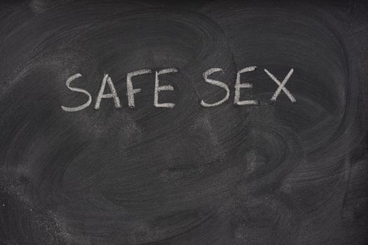 safe sex title handwritten with a white chalk on a school blackboard with strong eraser smudges