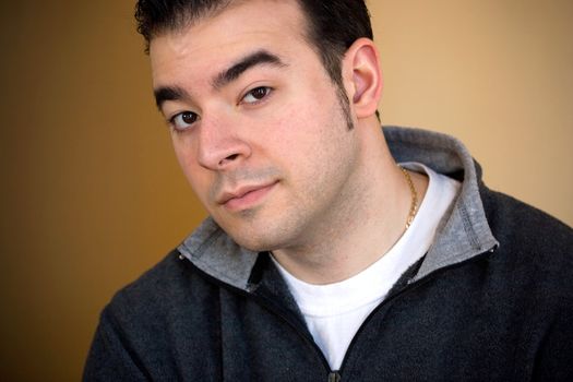 Portrait of a young man in his twenties over a golden background.