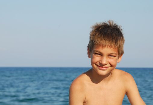 happy teen boy smiling portrait on seaside