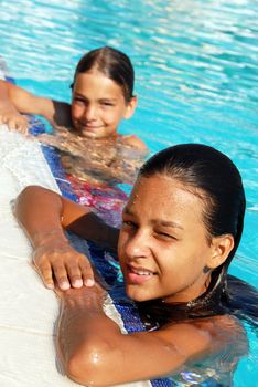 smiling girl and boy in blue swimming pool portrait