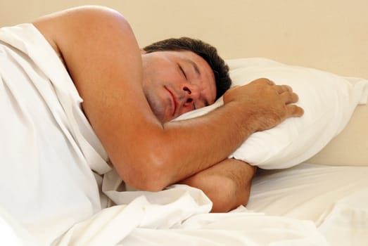 mature man sleeping on white pillow in bed