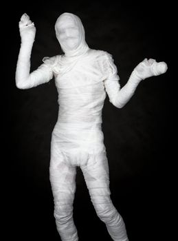 The man representing a mummy on black