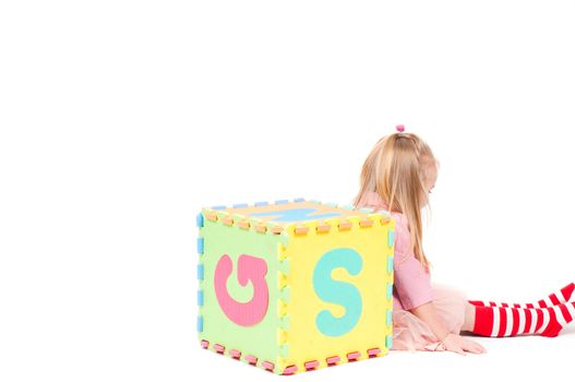 Studio shot of little girl who plaing with cube