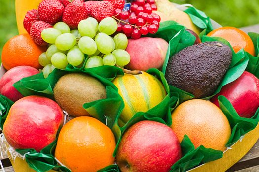 Selection of colorful, fresh, natural looking fruit, made up in a round box as a gift to a sick person. Close up image.