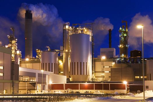 Paper mill on a winter night immediately after sunset, when sky has turned into beautiful blue.