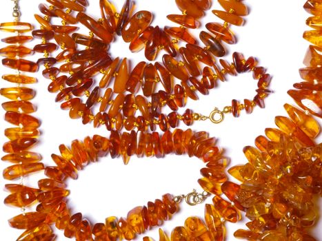 thread of amber beads on off- white background close up