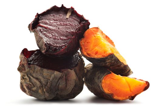 Grilled beet and carrot cut into pieces and stacked in a pile. Isolated on a white background.