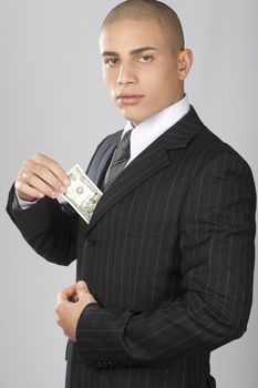A young good looking businessman on a gray background.