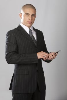 A young good looking businessman on a gray background.