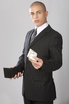 A young good looking businessman on a gray background.