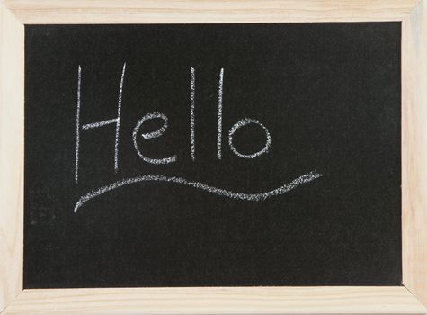 Black chalk board with wooden framed surround with the word Hello, underlined.